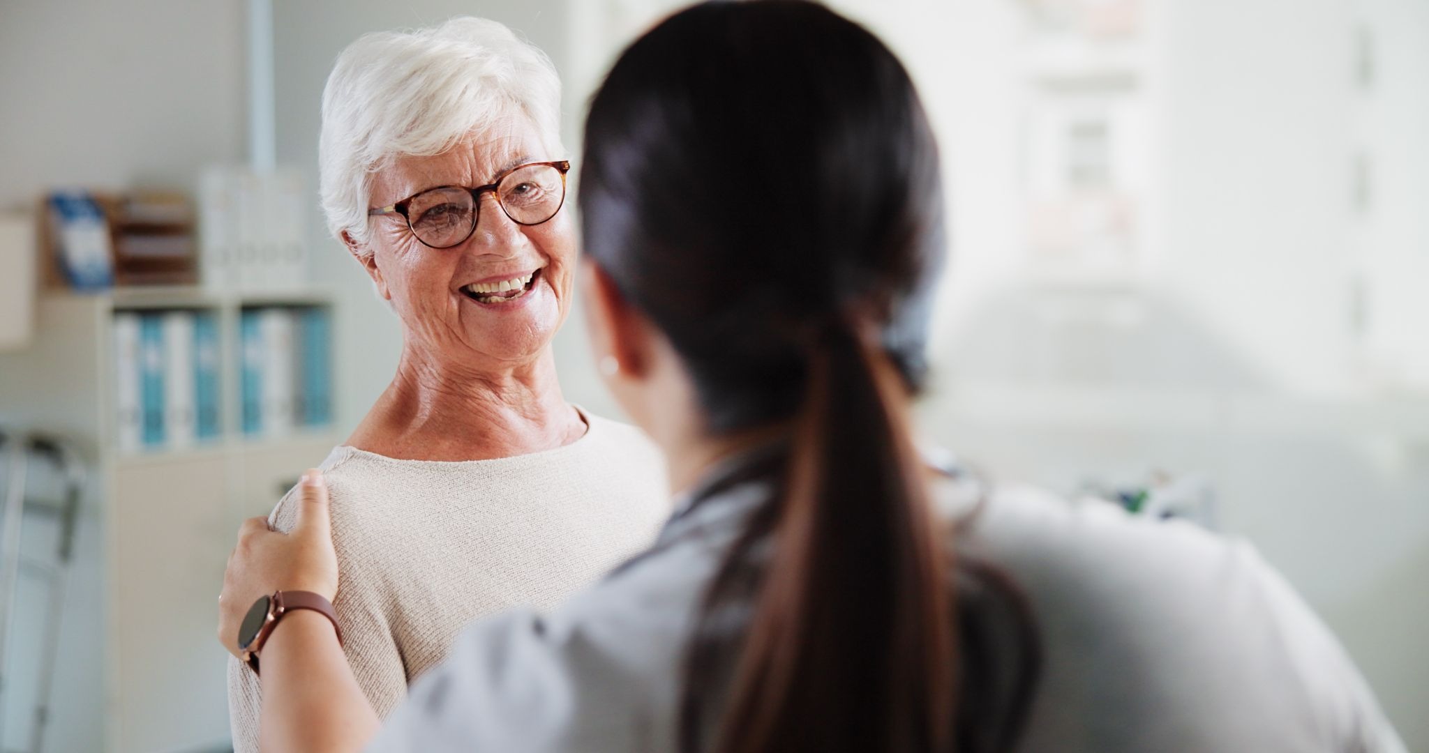 older woman having a warm, supportive conversation with a healthcare professional or caregiver