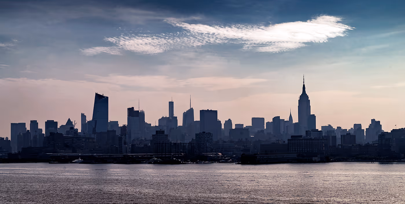 Silueta moderního velkoměsta nad vodní hladinou symbolizující globální stabilitu, mezinárodní pojištění a rozsah služeb makléře Eurovalley.