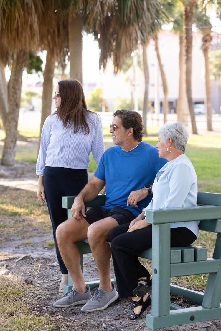 Geriatric care manager meeting with an older adult and family member in a park setting