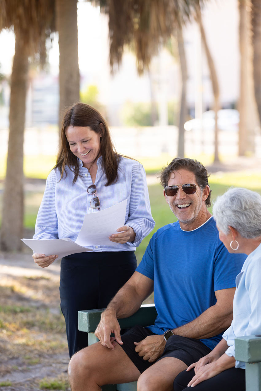 Geriatric care manager meeting with an older adult and family member in a park setting