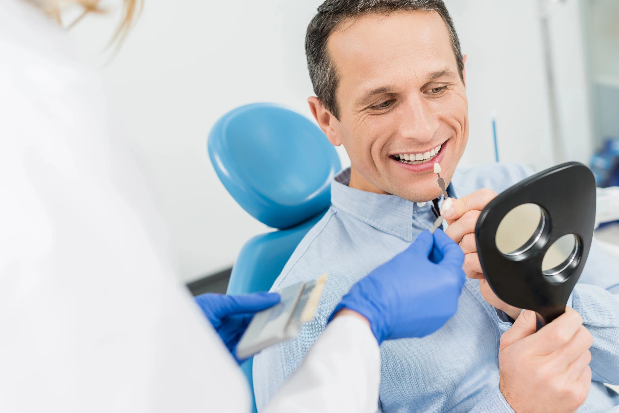 man looking at his dental implants in Michigan