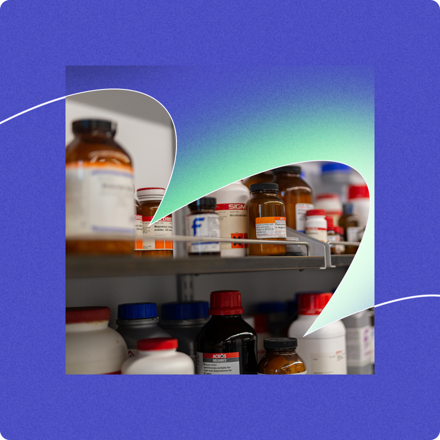 Shelves with various chemical bottles and containers organized in a laboratory setting.