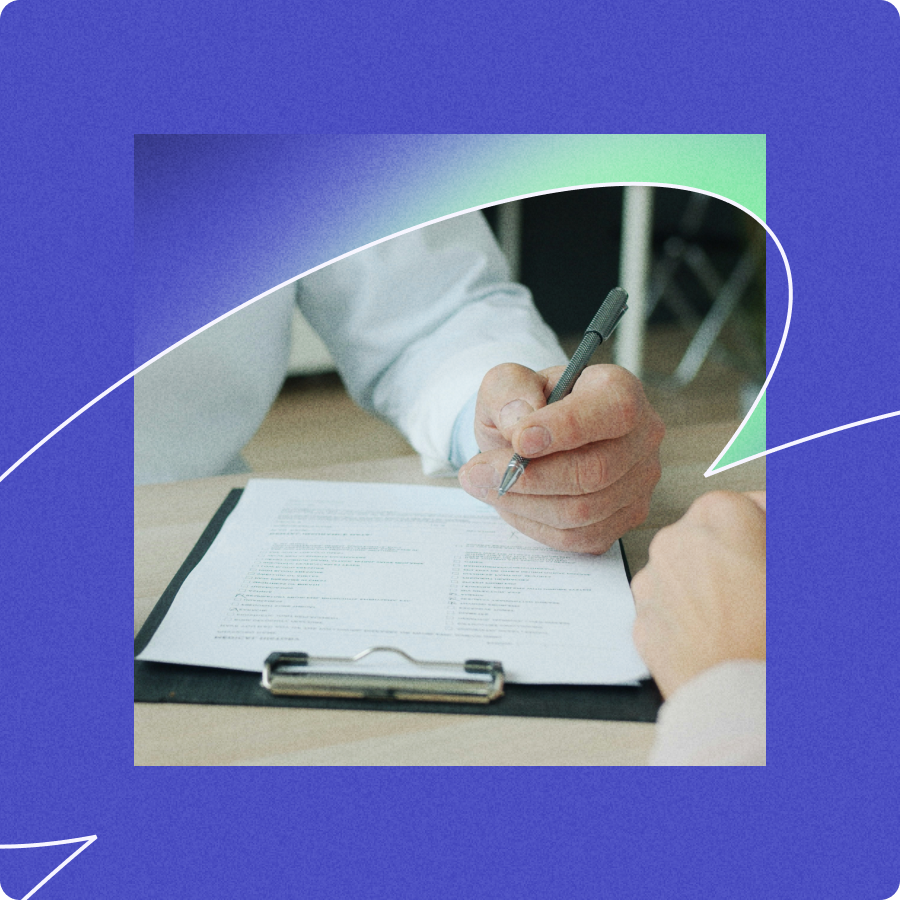 Person holding a pen and pointing to a document on a clipboard during a discussion.