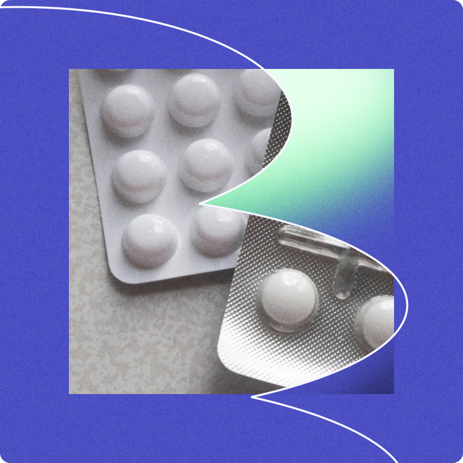 Two blister packs containing round white pills on a textured surface with a blue and green abstract background.