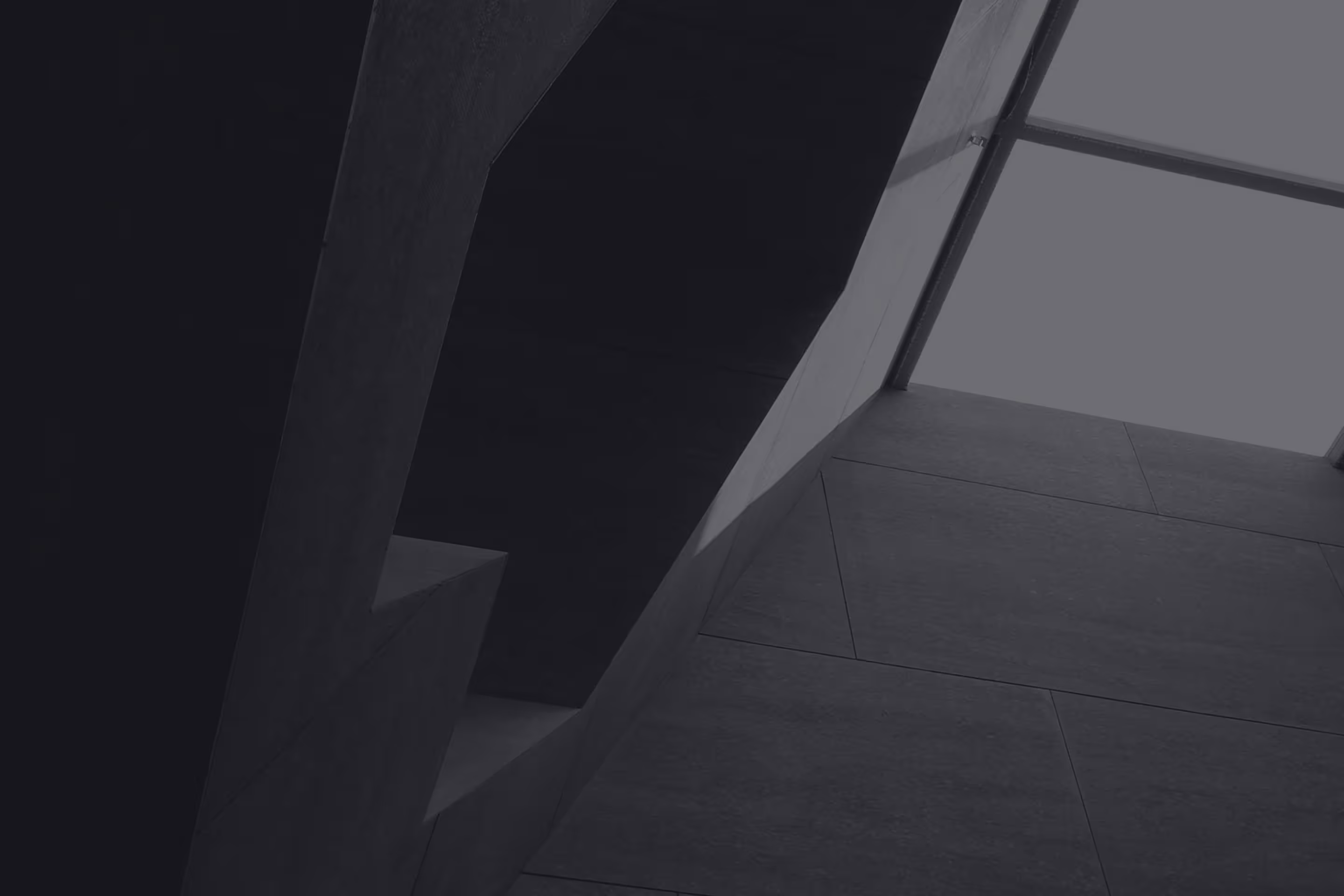 Modern architectural interior with geometric concrete walls and a large skylight window.