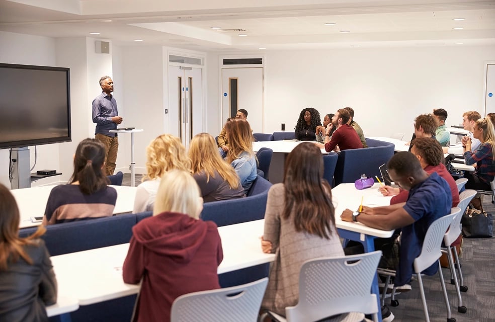 man teaching full classroom