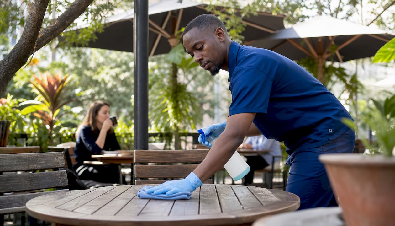 Janitor disinfecting office surfaces