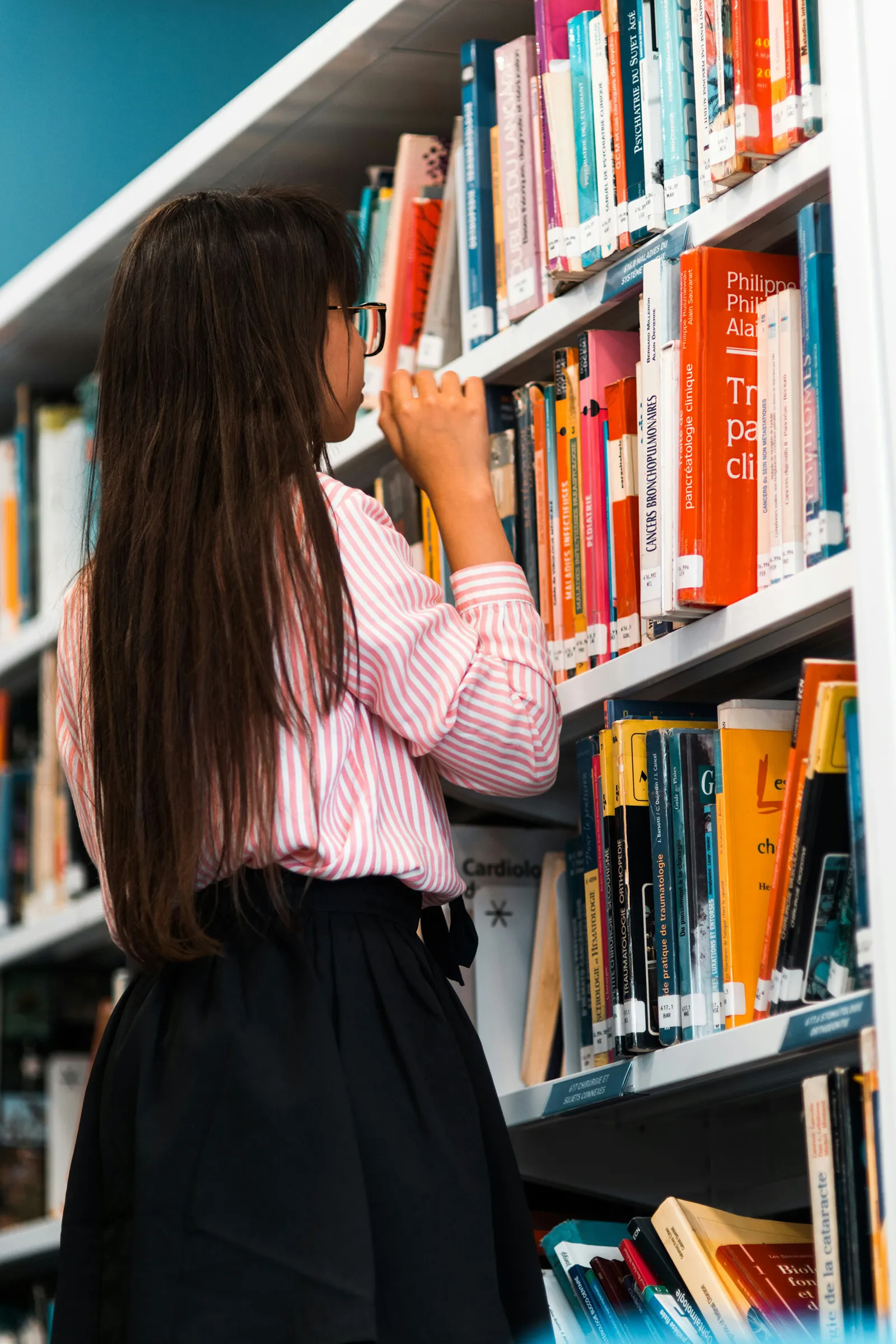 Girl looking for a book in the library