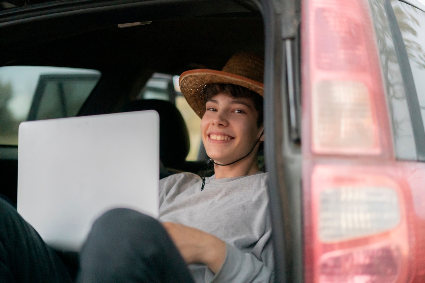 Montana high school student sitting in truck with laptop