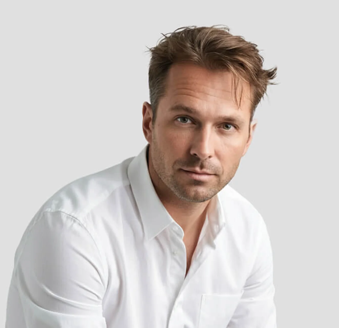 Portrait of a man sitting on a chair, looking forward.