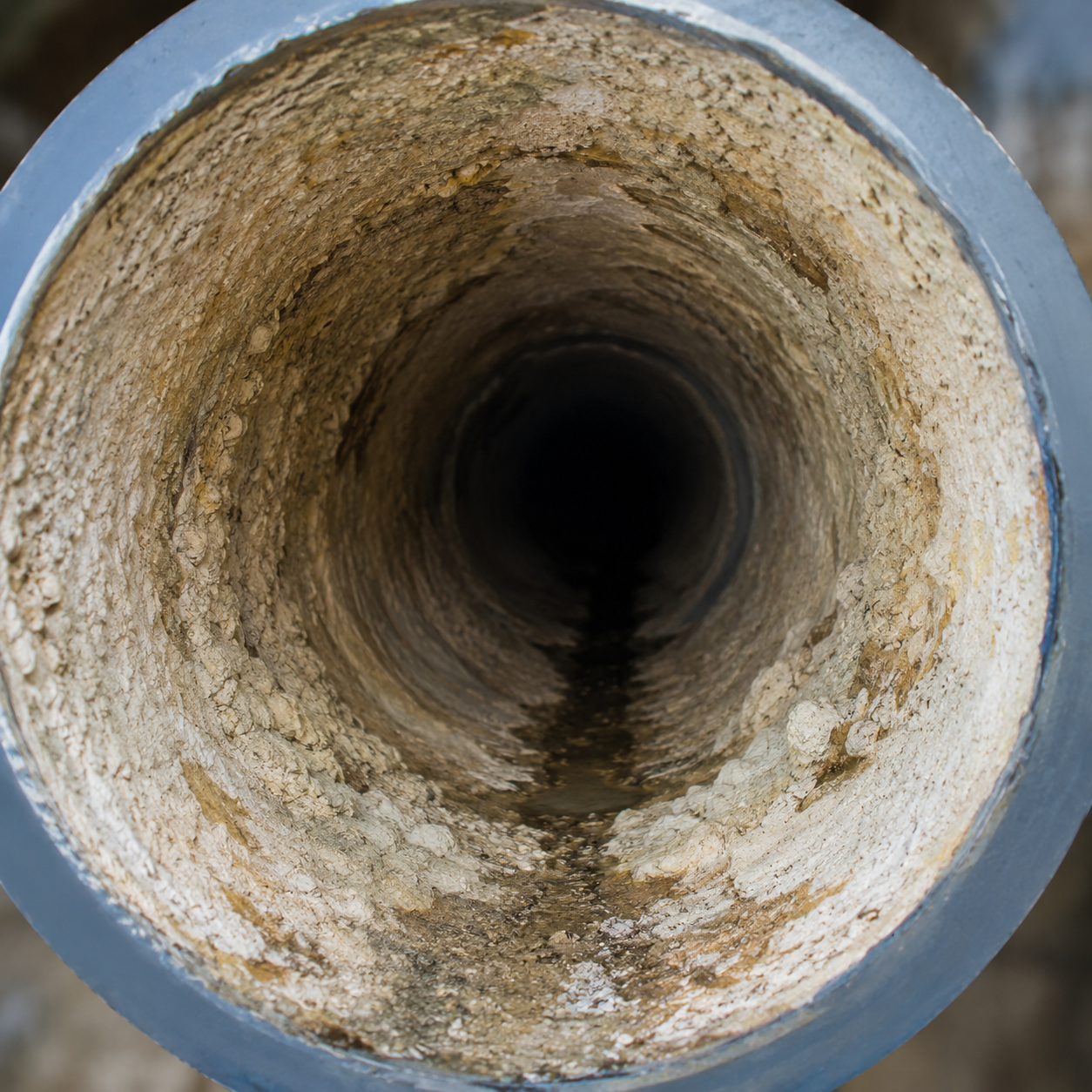 Internal view of a pipeline bore showing corrosion and mineral deposits before cleaning