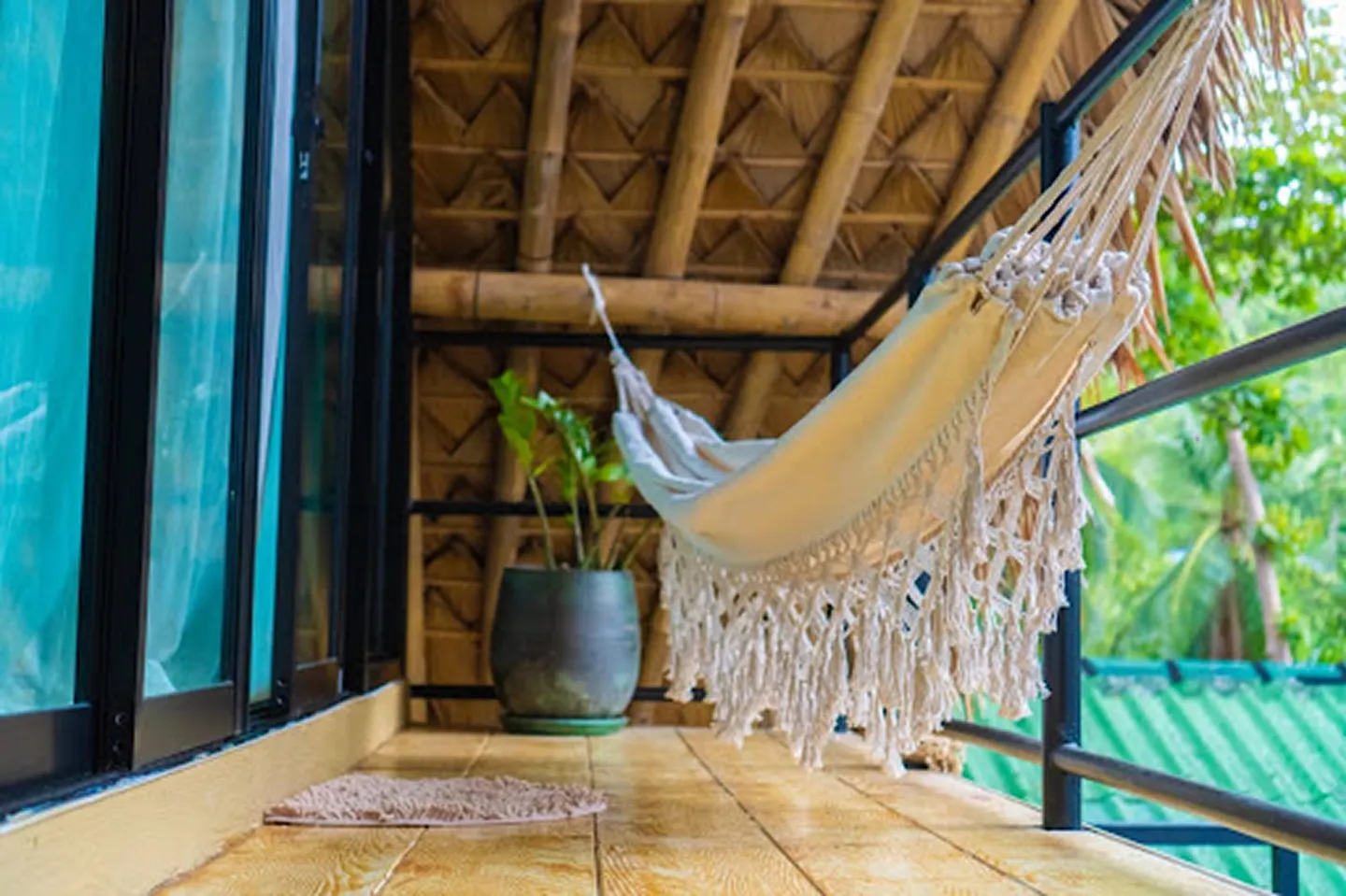 Treehouse-style bungalows with wooden decks and guests relaxing in jungle setting