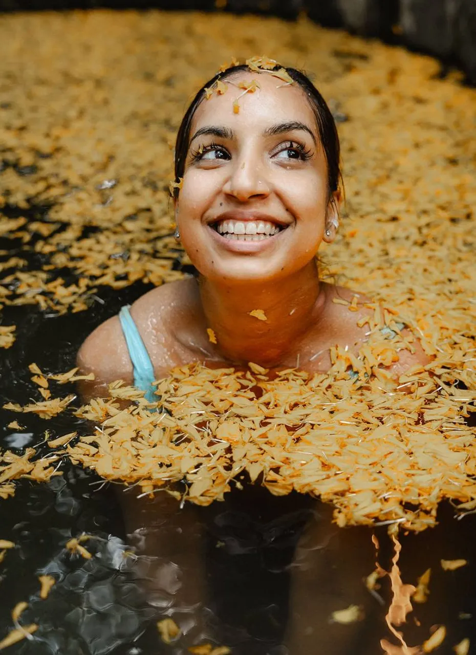 Smiling woman relaxing in flower bath at Shivari