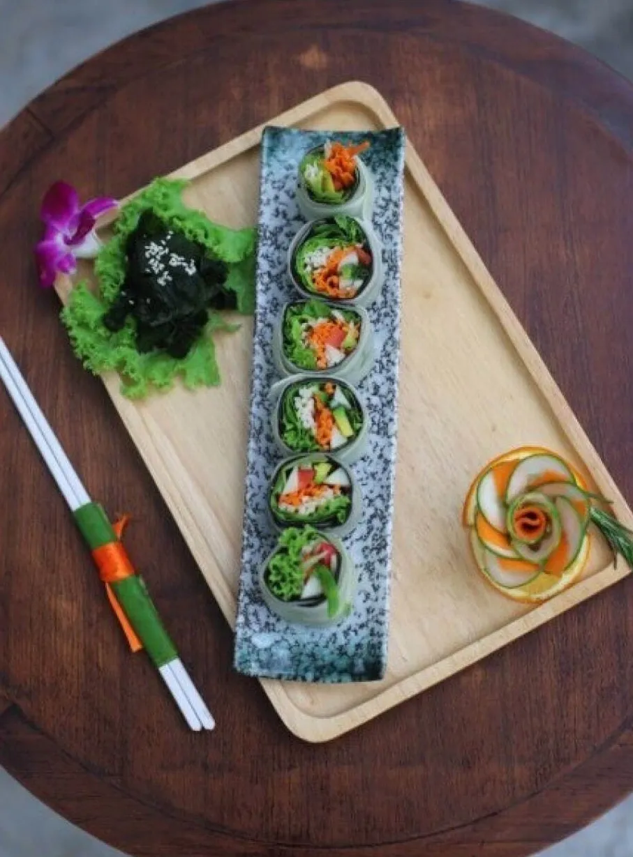 Raw vegan sushi rolls on wooden serving tray