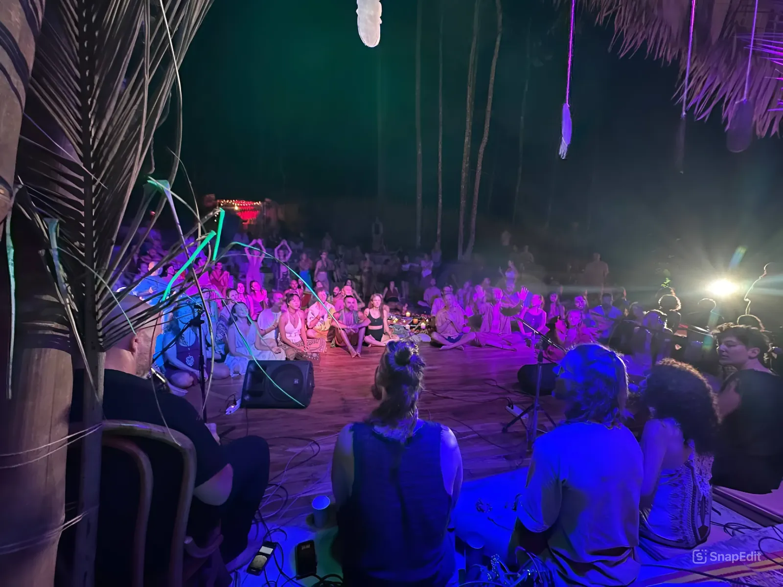 Performance space with purple lighting and audience at amphitheater event