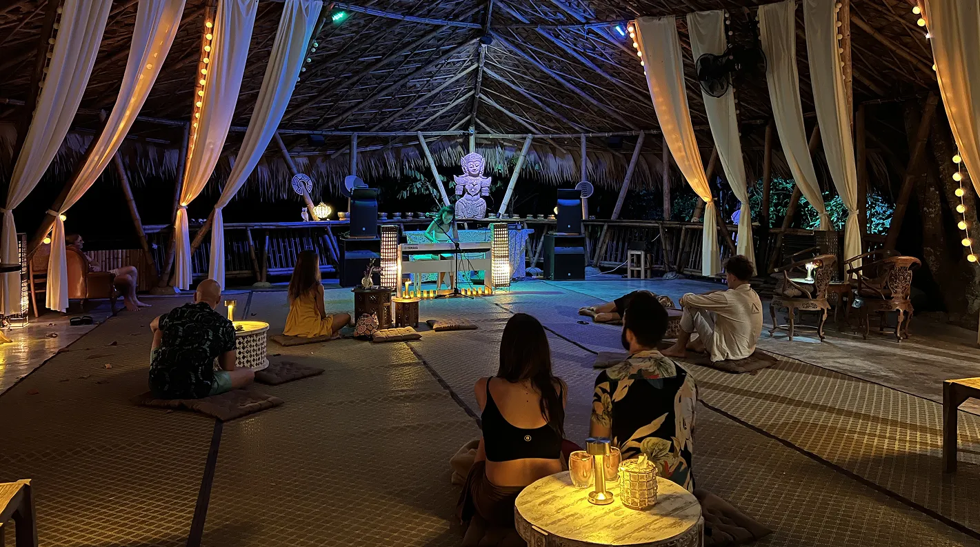 Evening ceremony with Buddha statue and ambient lighting in pavilion