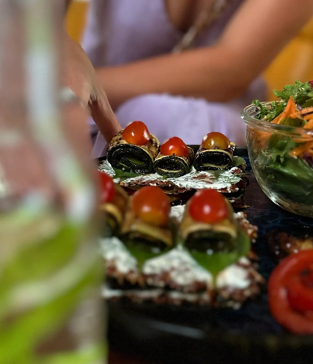 Close-up of raw vegan rolls with cherry tomatoes and fresh salad