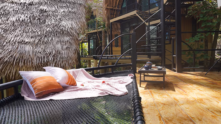 Thatched roof sala surrounded by tropical jungle and palm trees