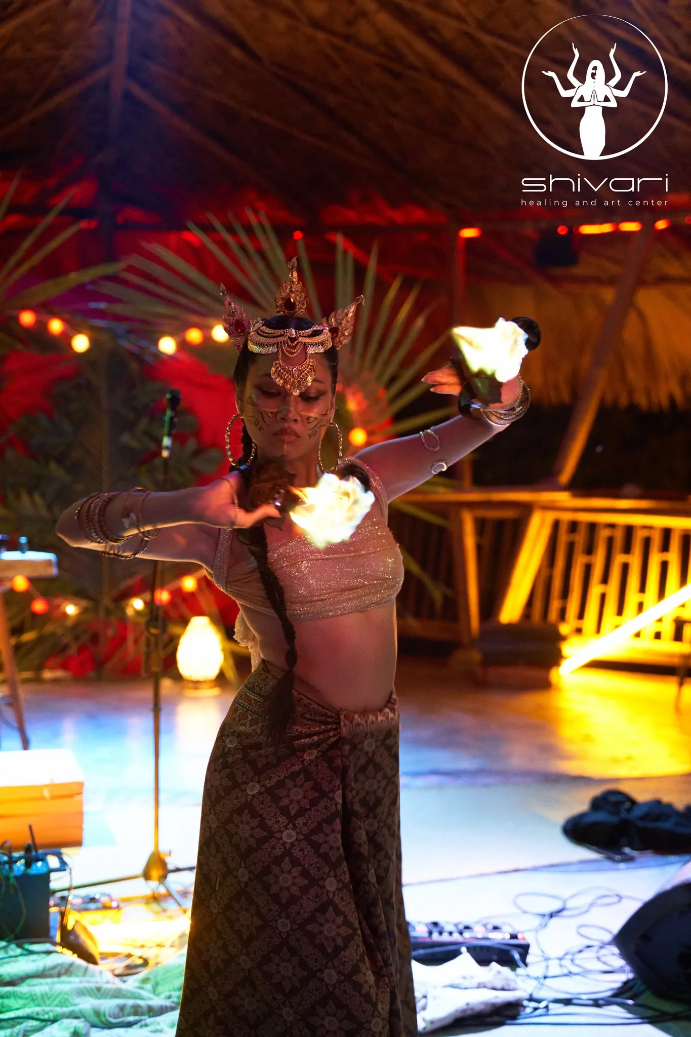 Traditional fire dancer in ornate costume performing at evening event