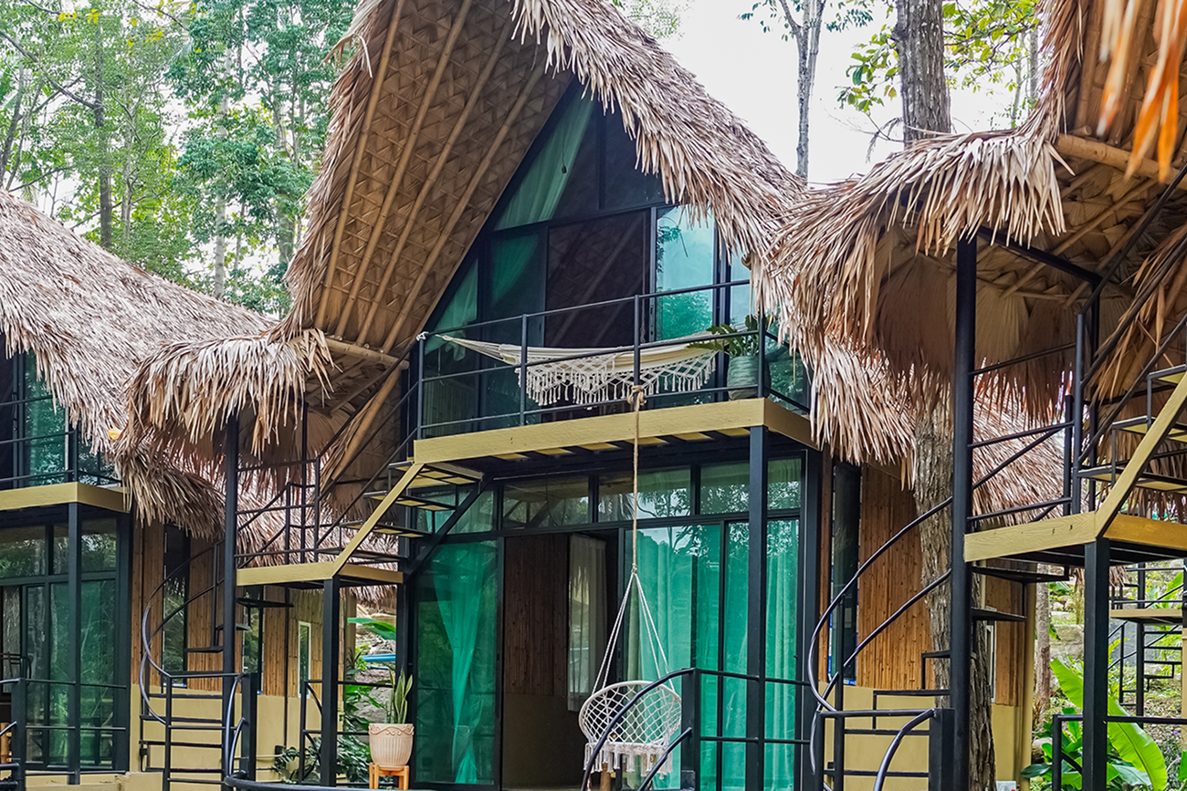 Jungle bungalows with thatched roofs and glass walls