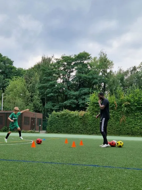 photo de coach Patrick sur terrain de football il entraine Leon un joueur