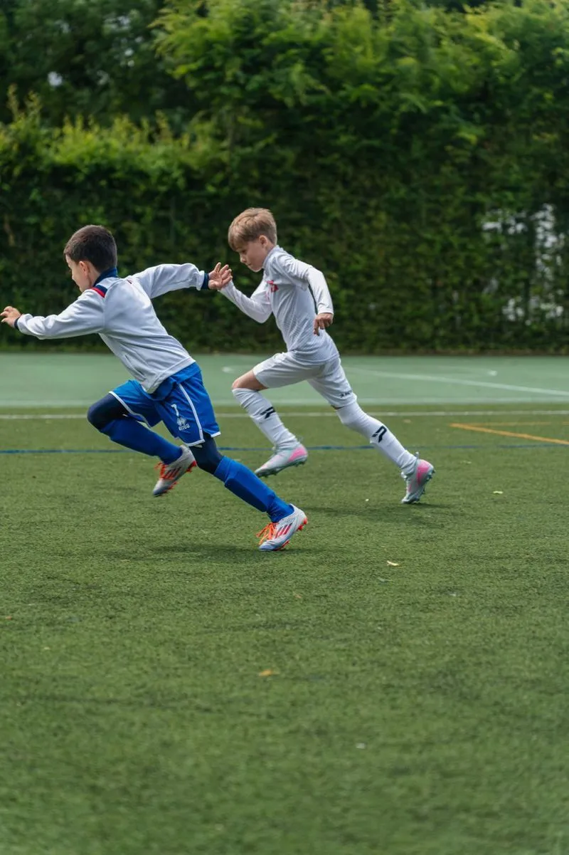 photo des enfants Samuel et Nicolas qui courent sur un terrain de football à l'entrainement