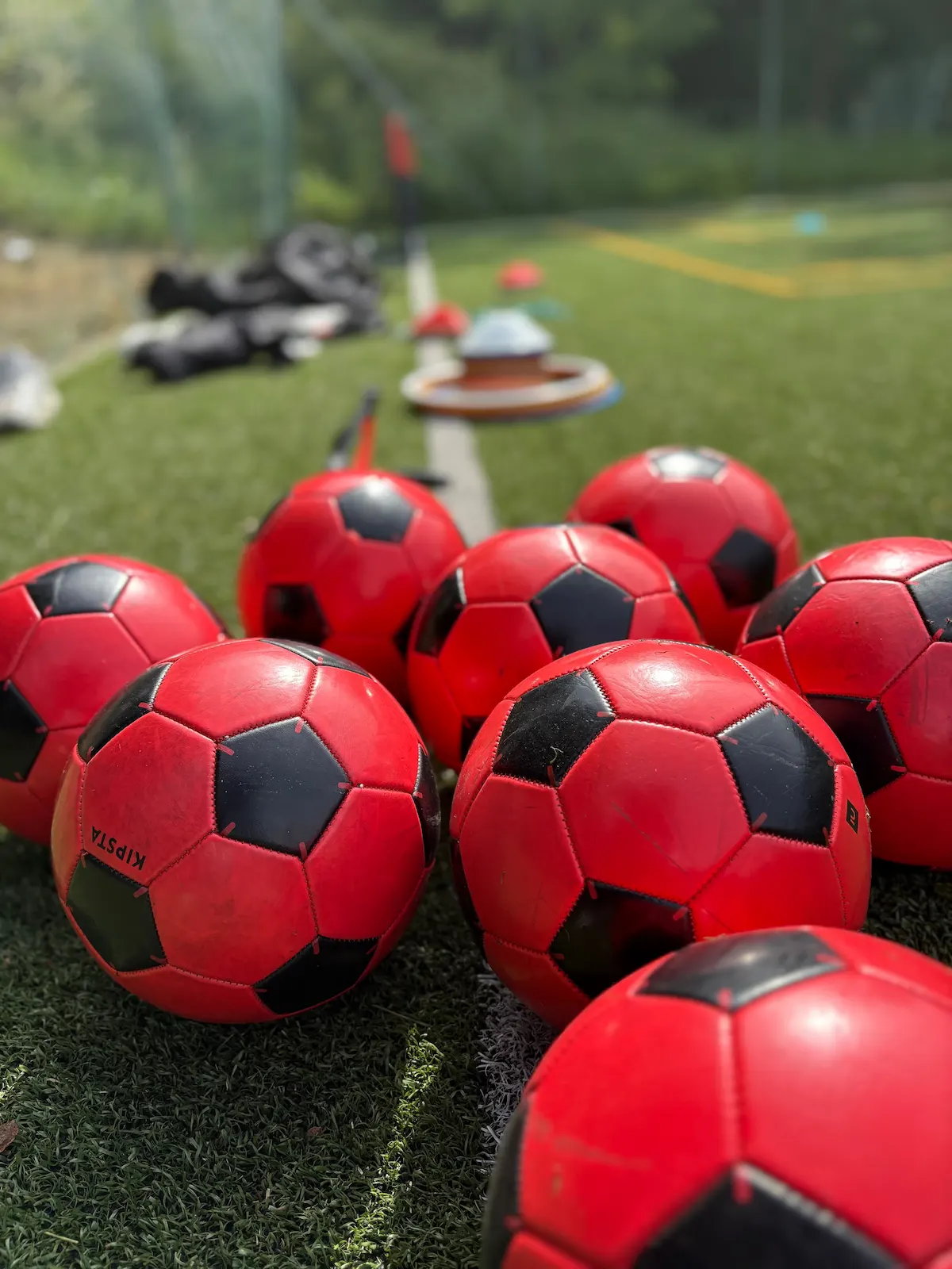 huits ballons rouge de football sur un terrain de football