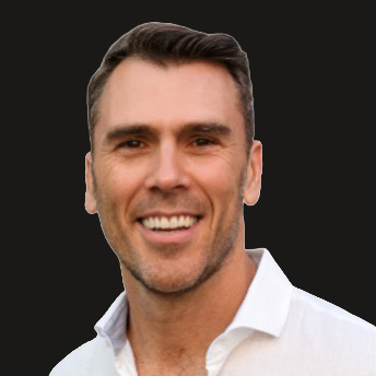 Smiling man with short dark hair wearing a white shirt against a dark background.