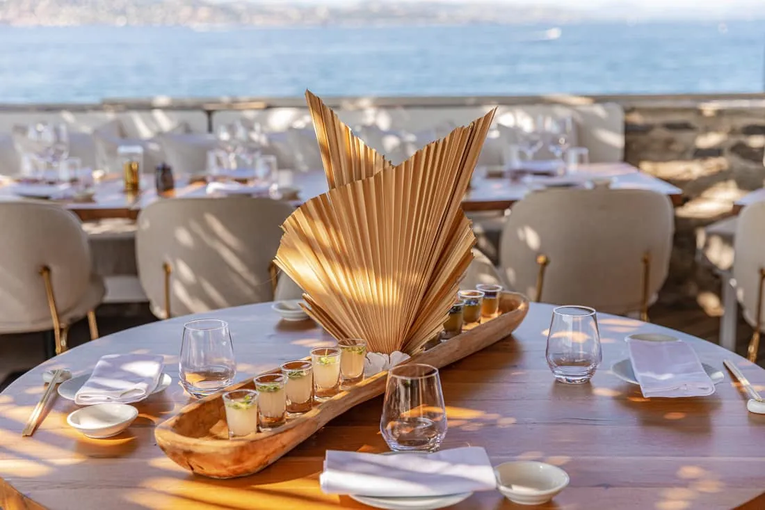 Table dressée en terrasse face à la mer pour une dégustation de cocktails
