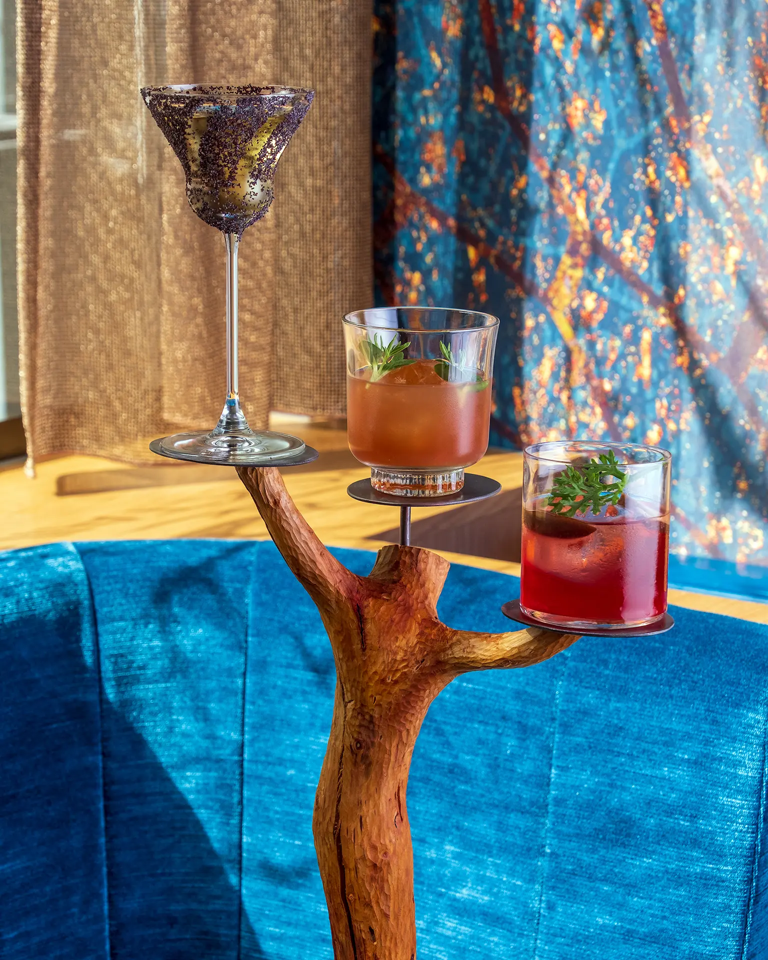 Trois cocktails présentés sur un support en bois brut