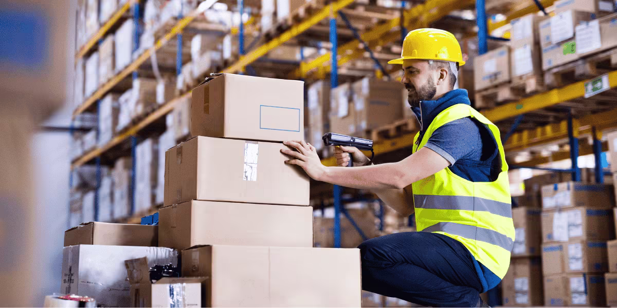 Un homme scanne des cartons dans un entrepôt