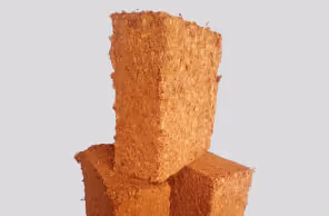 Three stacked rectangular blocks of coarse brown coir fiber against a light gray background.