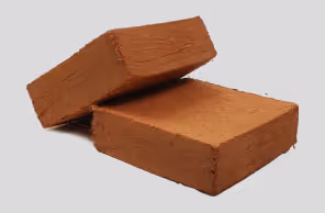 Two rectangular compressed blocks of brown coir fiber stacked on a gray background.