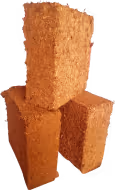 Three brown compressed coconut coir fiber bricks stacked together.