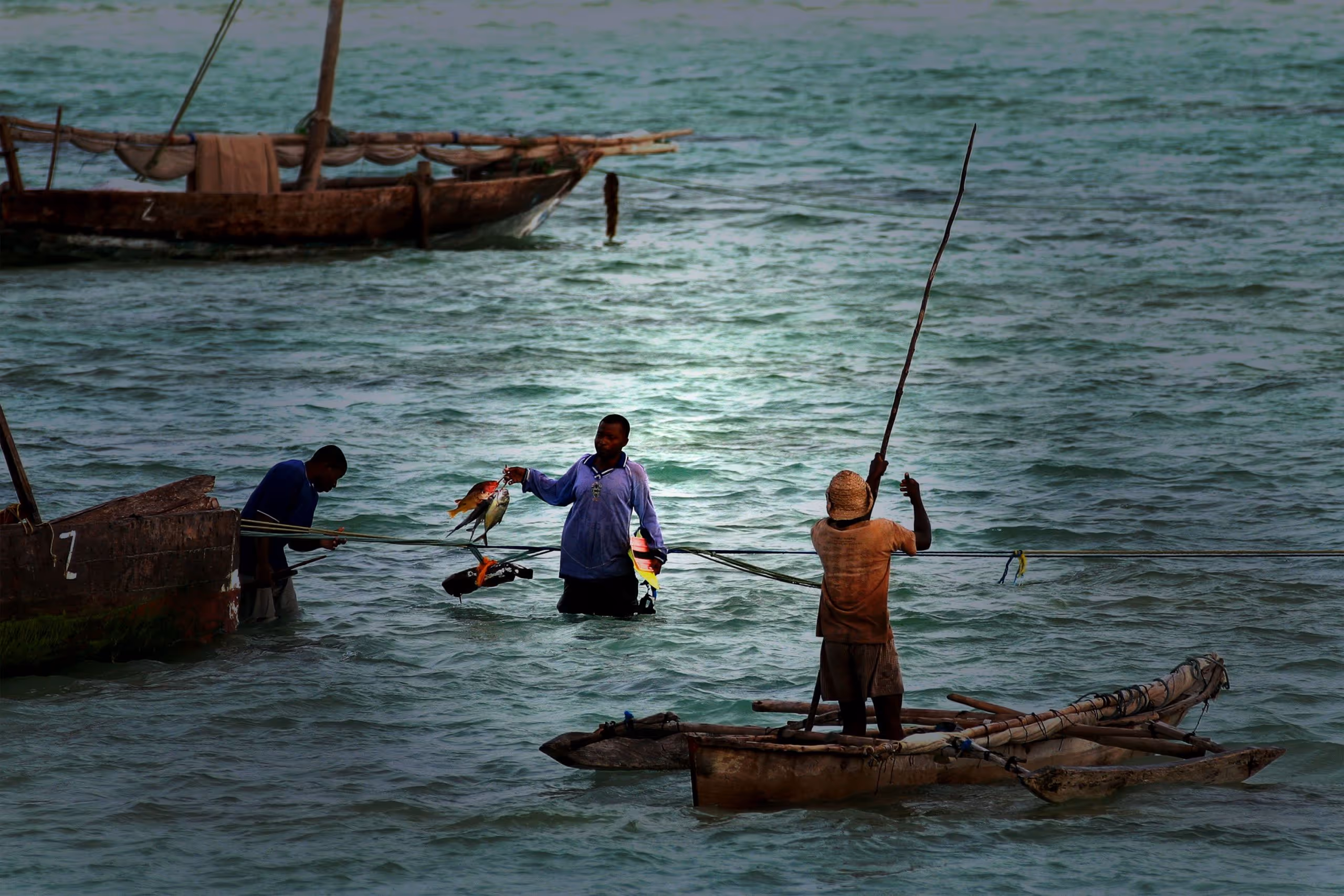 Men at sea fishing on small boats