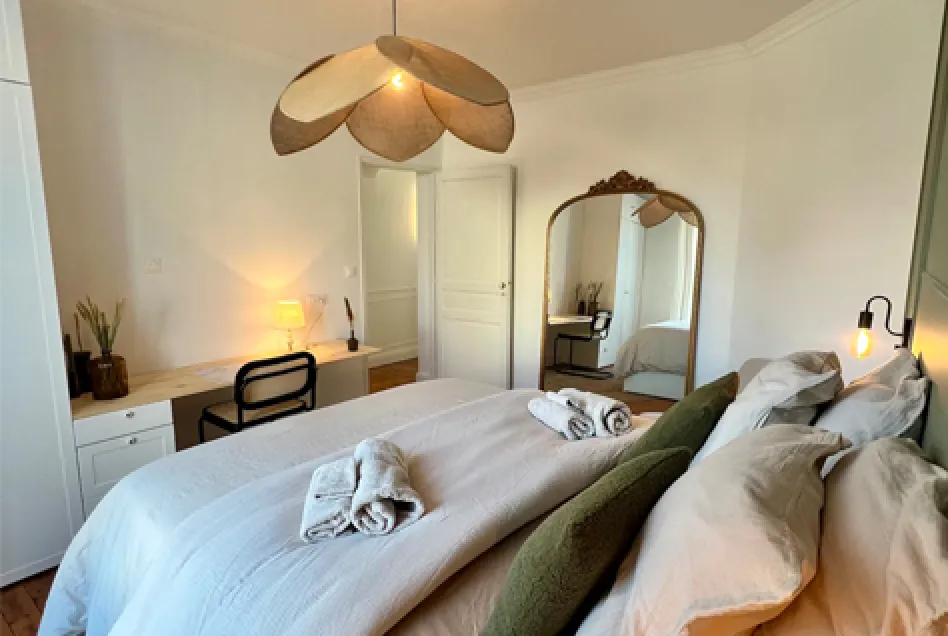 Modern living room with beige sofa, wooden TV stand, sliding glass doors opening to a balcony with ocean view.