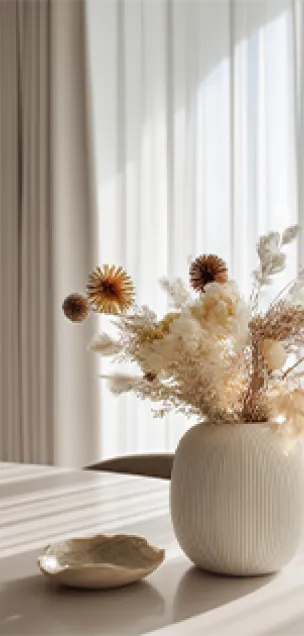 Beach house on stilts overlooking ocean waves during sunset with sandy dunes and vegetation in foreground.