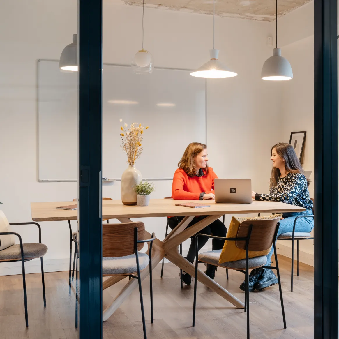 Deux personnes discutant dans une salle de réunion