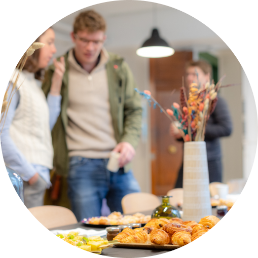 Des personnes discutant dans un open space avec des croissants sur la table