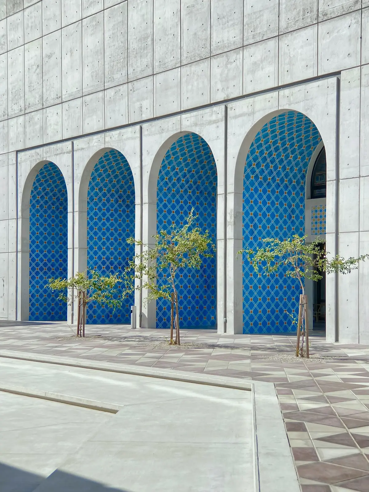 Modern Middle Eastern architecture in Abu Dhabi with arched facades and plants, designed for comfortable living