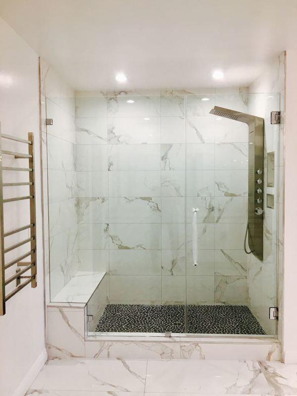 Walk-in shower installation Los Angeles with large format marble tile and frameless glass enclosure