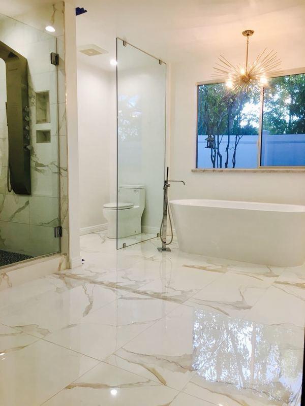 Luxury bathroom remodel Los Angeles with freestanding tub, frameless glass shower and marble tile flooring