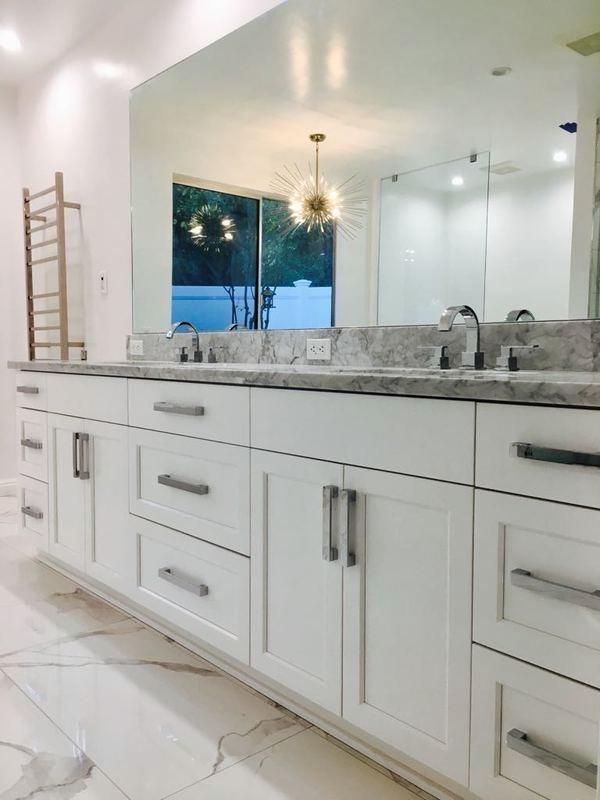 Double vanity bathroom remodel Los Angeles with white shaker cabinets and gray marble countertop