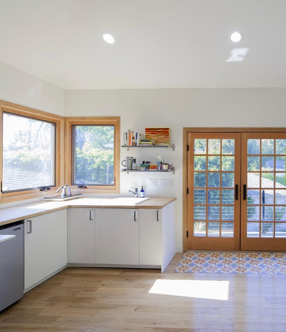 ADU kitchen build-out Los Angeles with white cabinets, recessed lighting and French doors
