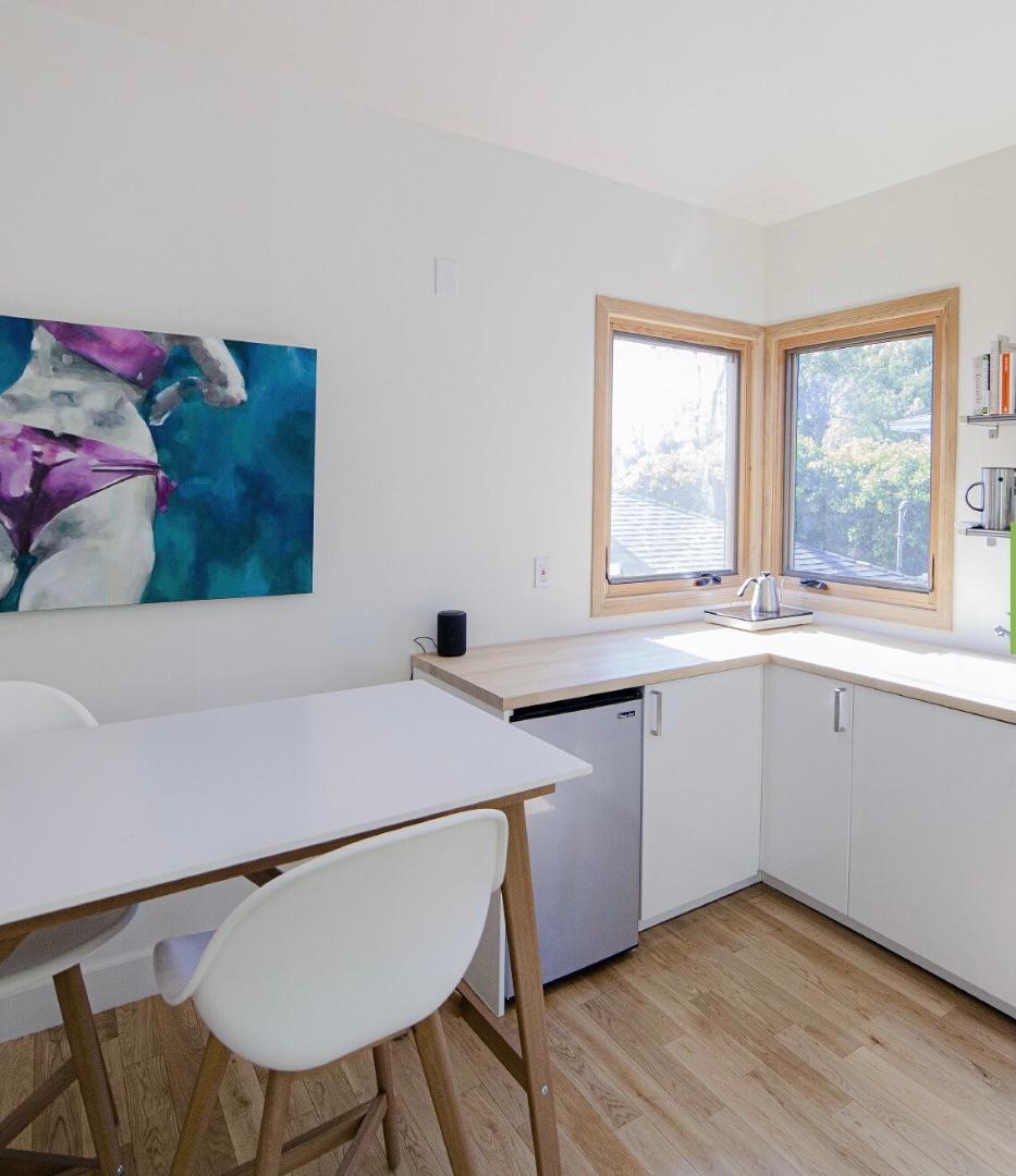 JADU interior Los Angeles with compact kitchen, white cabinets and wood countertop