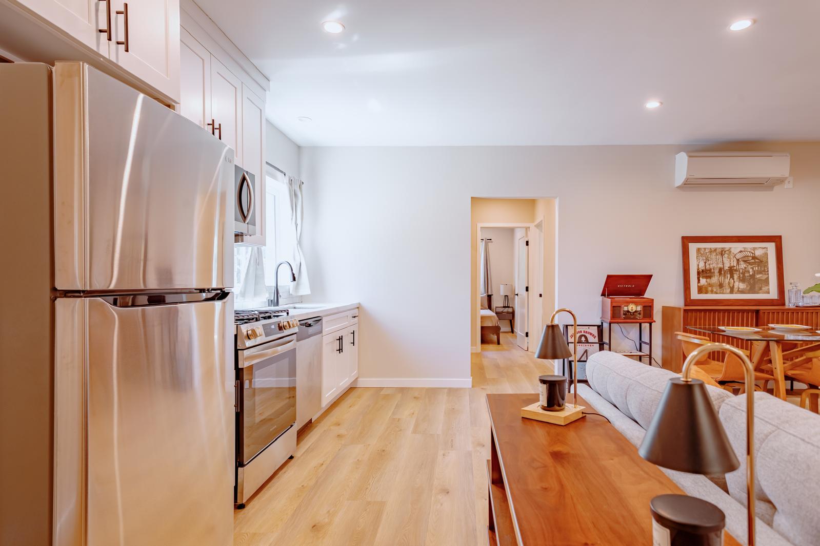 Fully finished ADU interior Los Angeles with white kitchen cabinets, stainless appliances and open living space