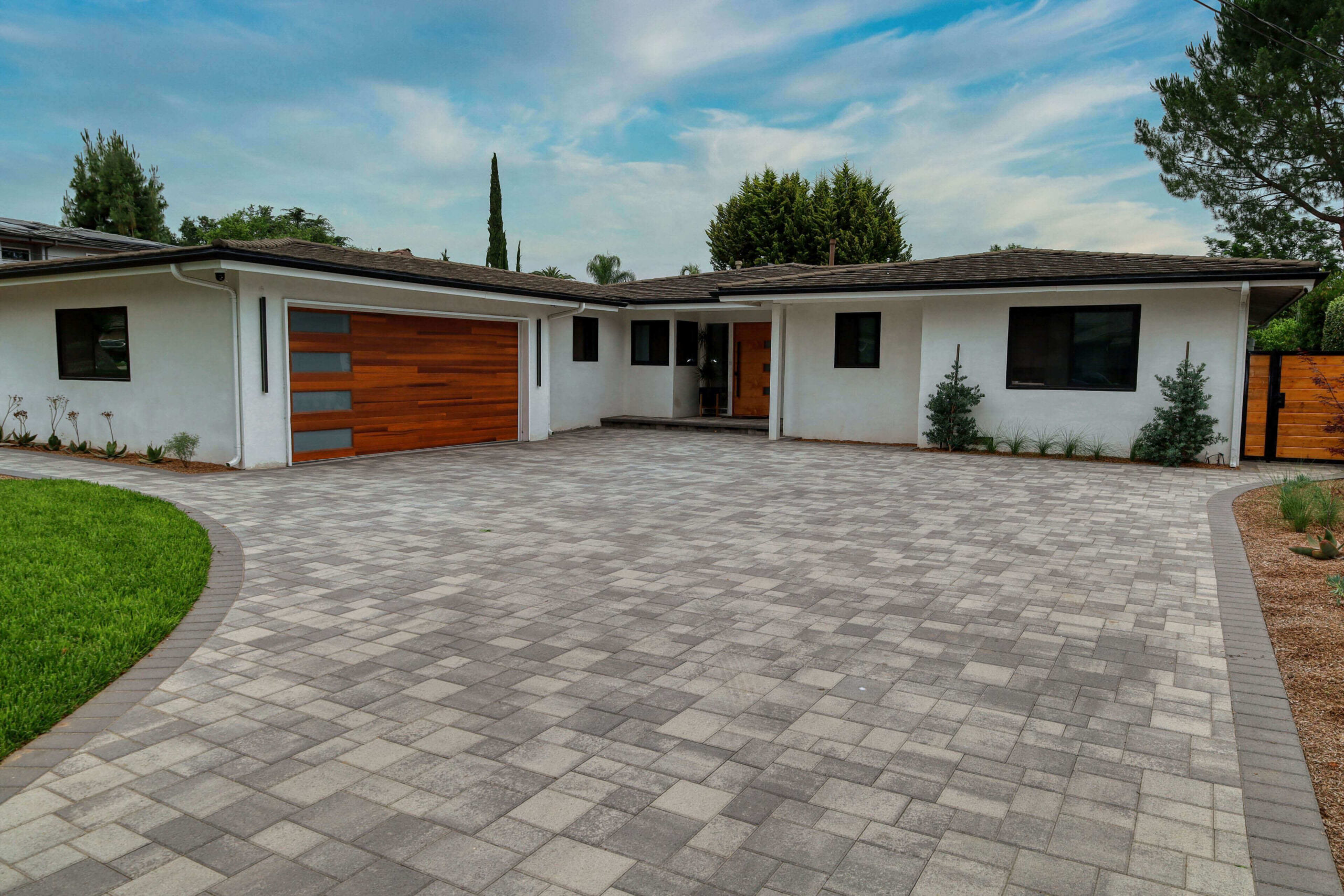 Garage exterior upgrade Los Angeles with wood accent door and paver driveway installation