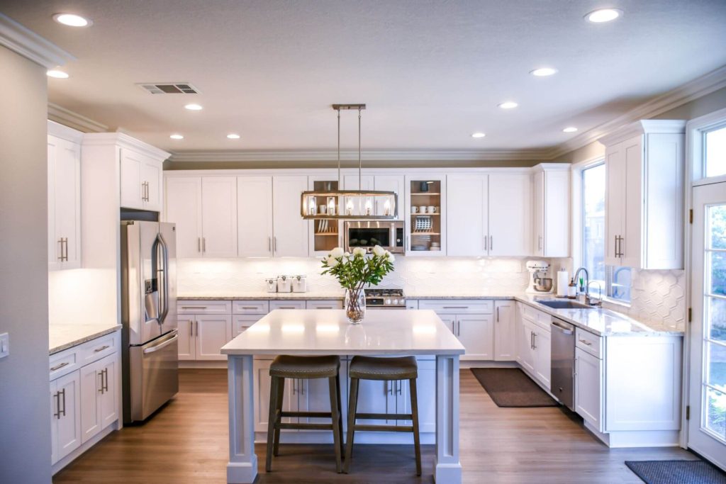 Custom kitchen renovation Los Angeles featuring large island, pendant lighting and hardwood flooring
