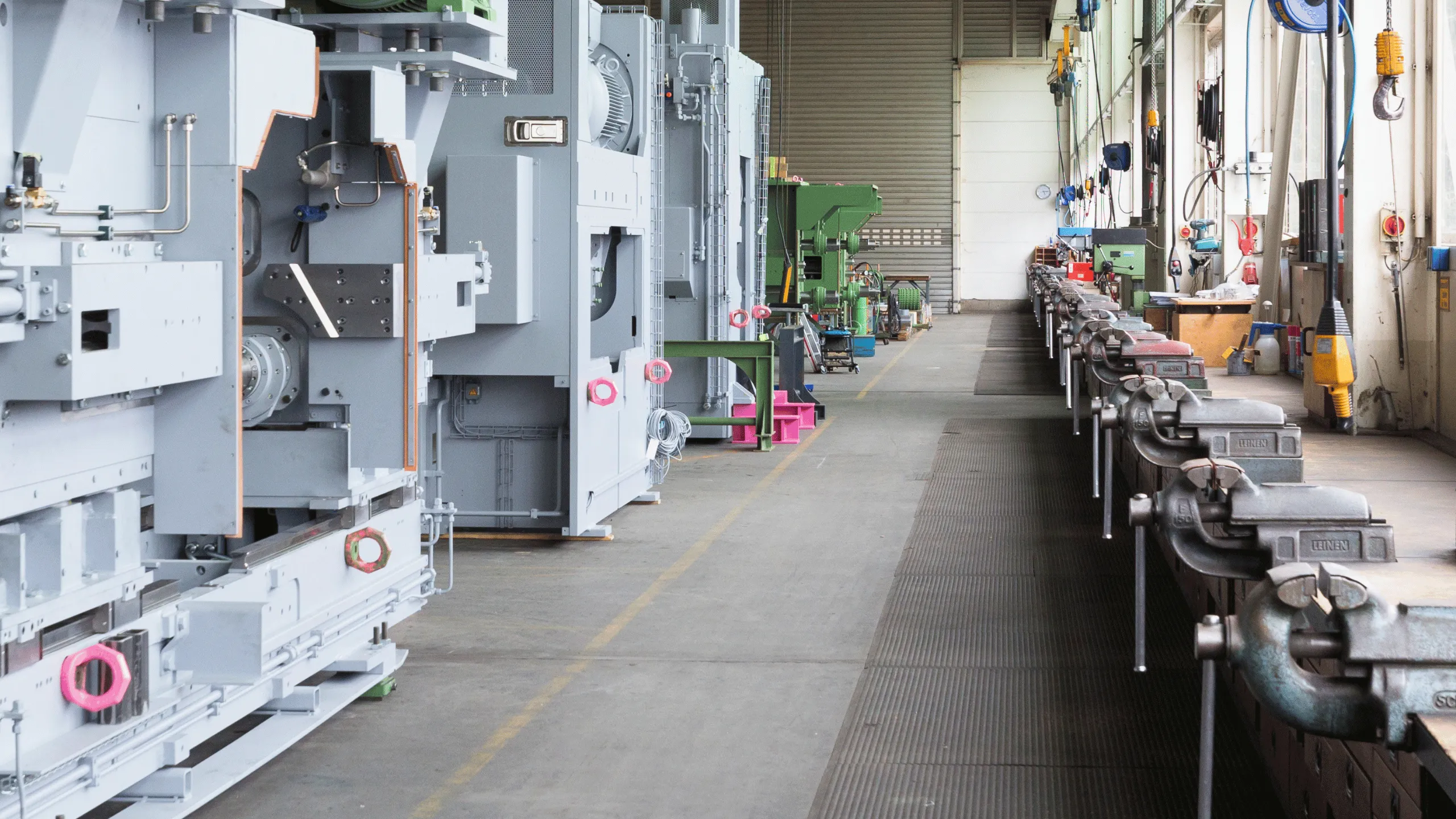 Werksmontage bei LINCK mit Werkbank auf der rechten Seite und einer aufgebauten, lichtgrauen Maschine auf der linken Seite.