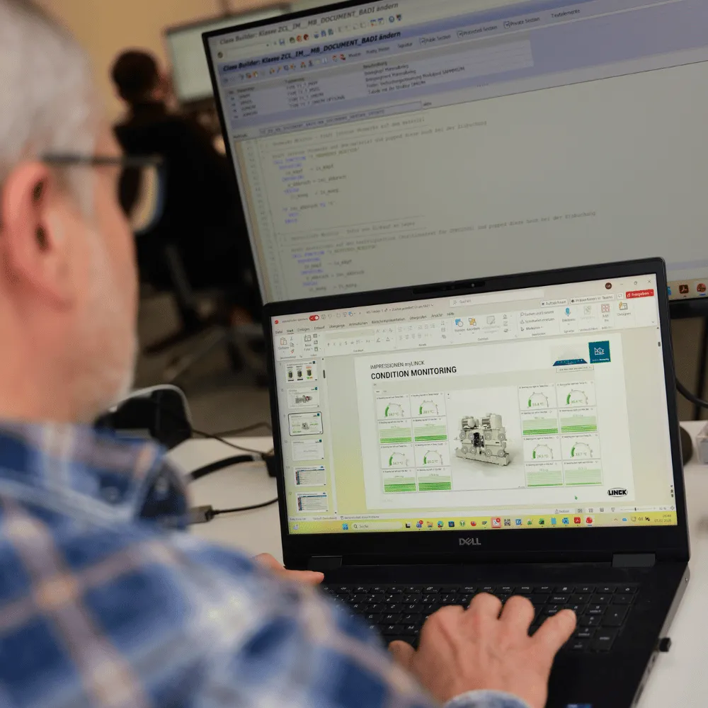 LINCK-Mitarbeiter arbeitet am myLINCK Dashboard, das über die Schulter auf dem Bildschirm sichtbar ist